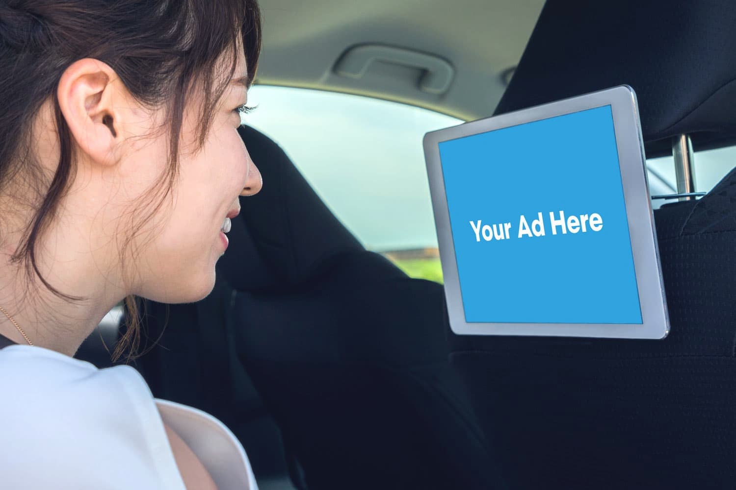 A tablet mounted on a car's headrest.