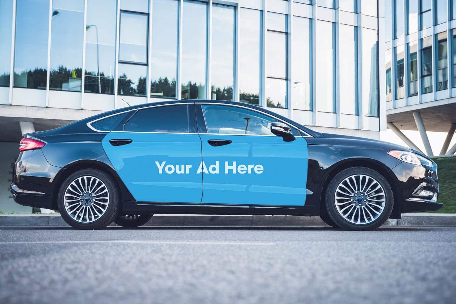 A vinyl ad wrapped onto the doors of a sedan.